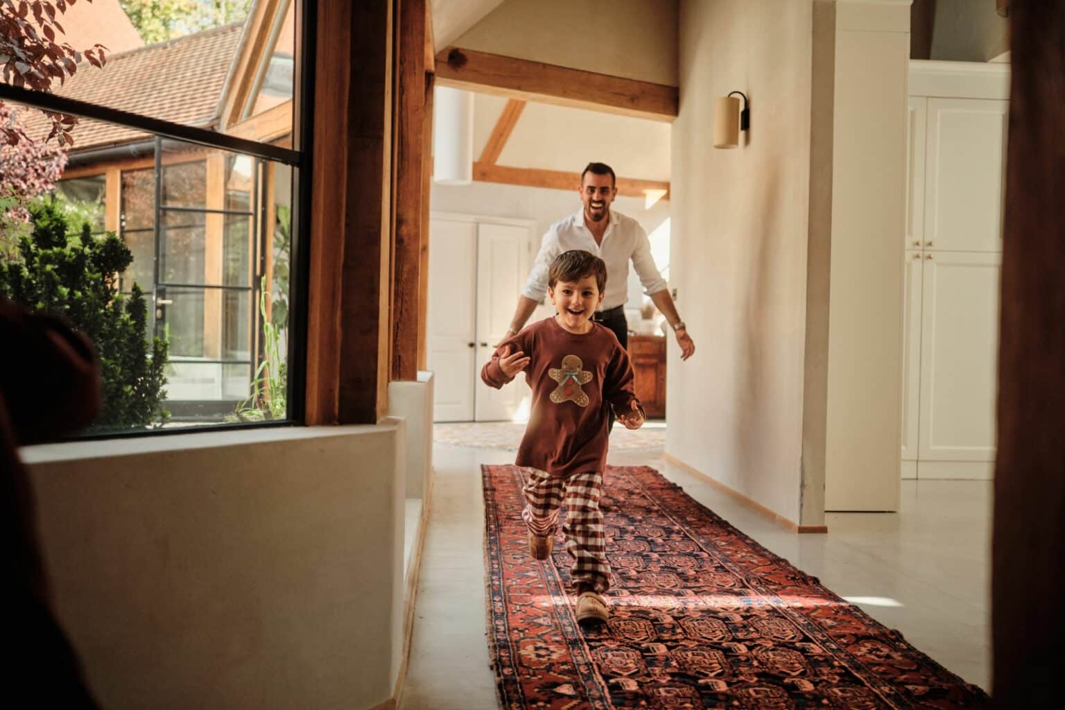 Father and son playing, running through the hallways on a Persian carpet/runner/